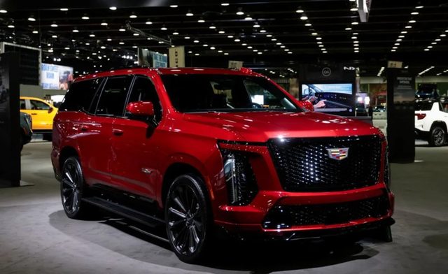 Tableau de bord d'un SUV électrique Cadillac Lyriq affichant un témoin d'alerte de freinage, en roulage sur route