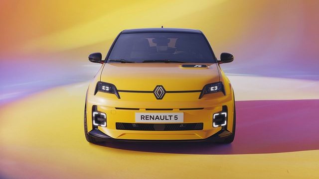 Une Renault 5 E-Tech jaune est garée en trois-quarts avant dans une rue urbaine française