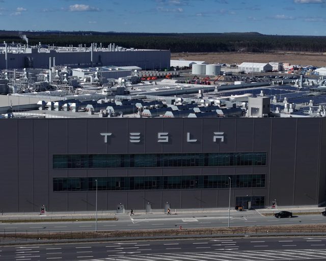 Des dizaines de Tesla Model 3 et Model Y alignées en légère plongée sur le parking de la Gigafactory de Shanghai