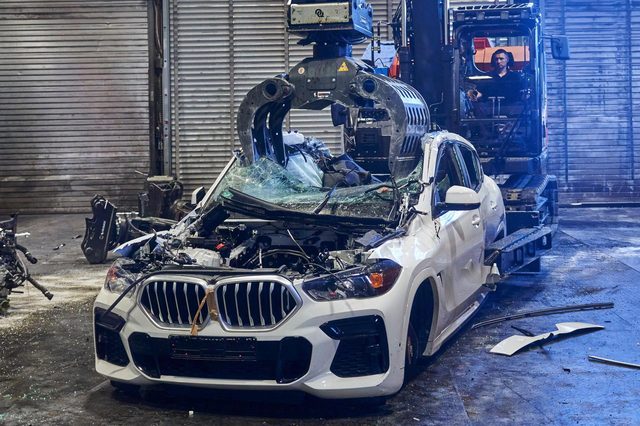 Des pièces métalliques BMW recyclées avancent dans un atelier de production moderne au cadrage large