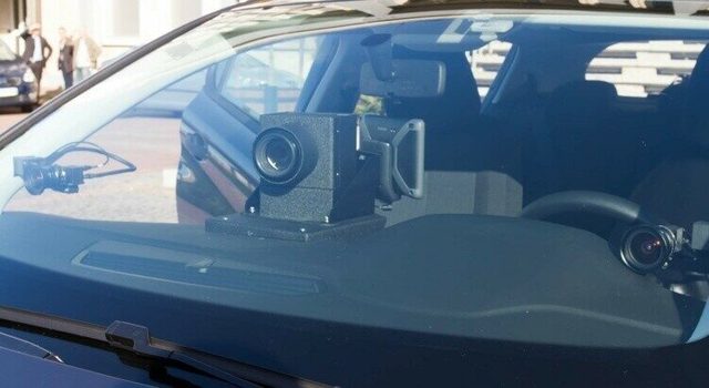 Une berline banalisée grise circule discrètement sur une route française en trafic réel