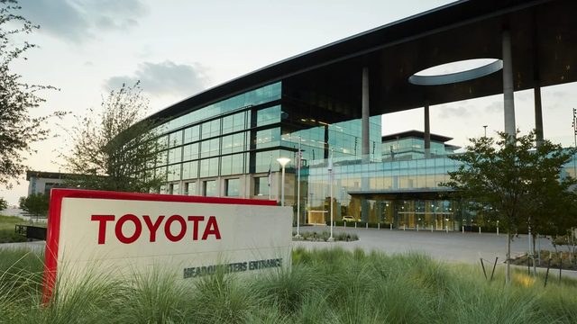 Niki Allen pose dans un bureau moderne avec un logo Toyota discret en arrière-plan