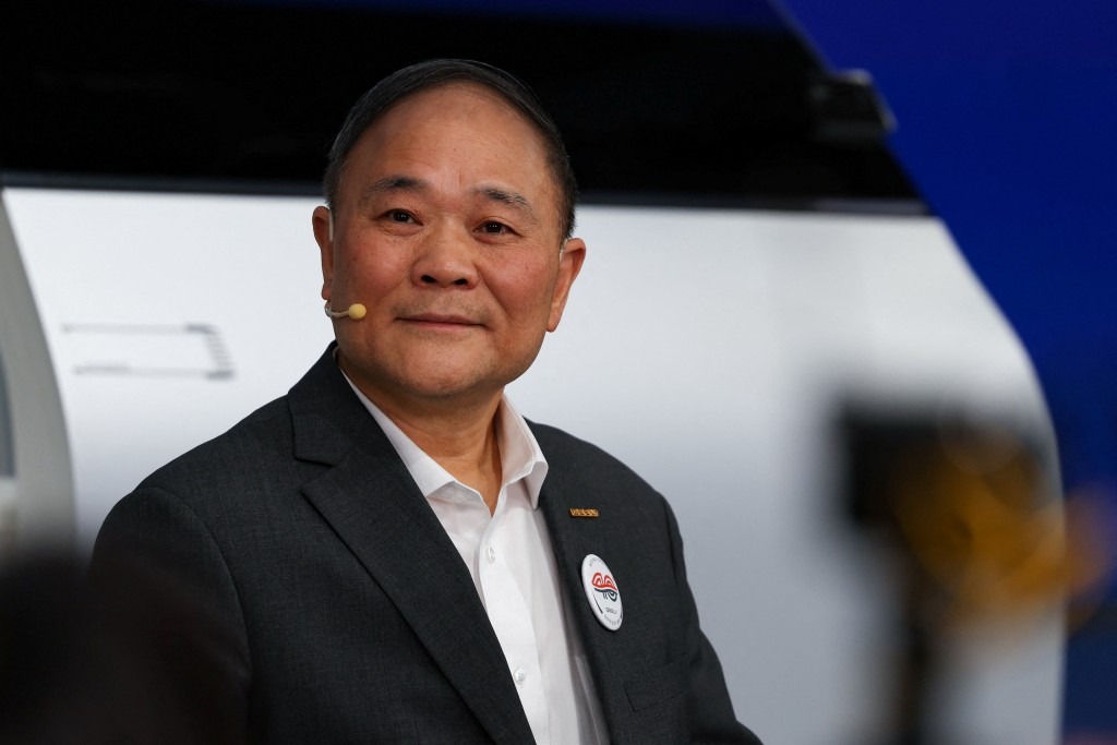 Li Shufu et An Conghui posent lors d’un événement corporate Geely sur fond de conférence sobre