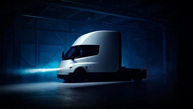 Tesla Semi vu de trois quarts avant sur un stand de salon professionnel européen, public en arrière-plan