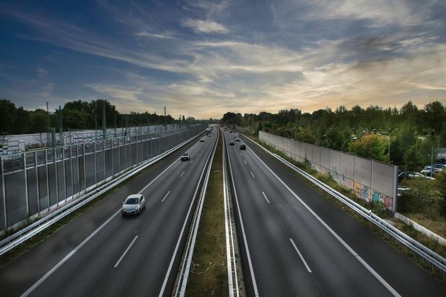 Une Renault Mégane E-Tech vue de trois quarts avant est branchée à une borne rapide sur une aire d’autoroute